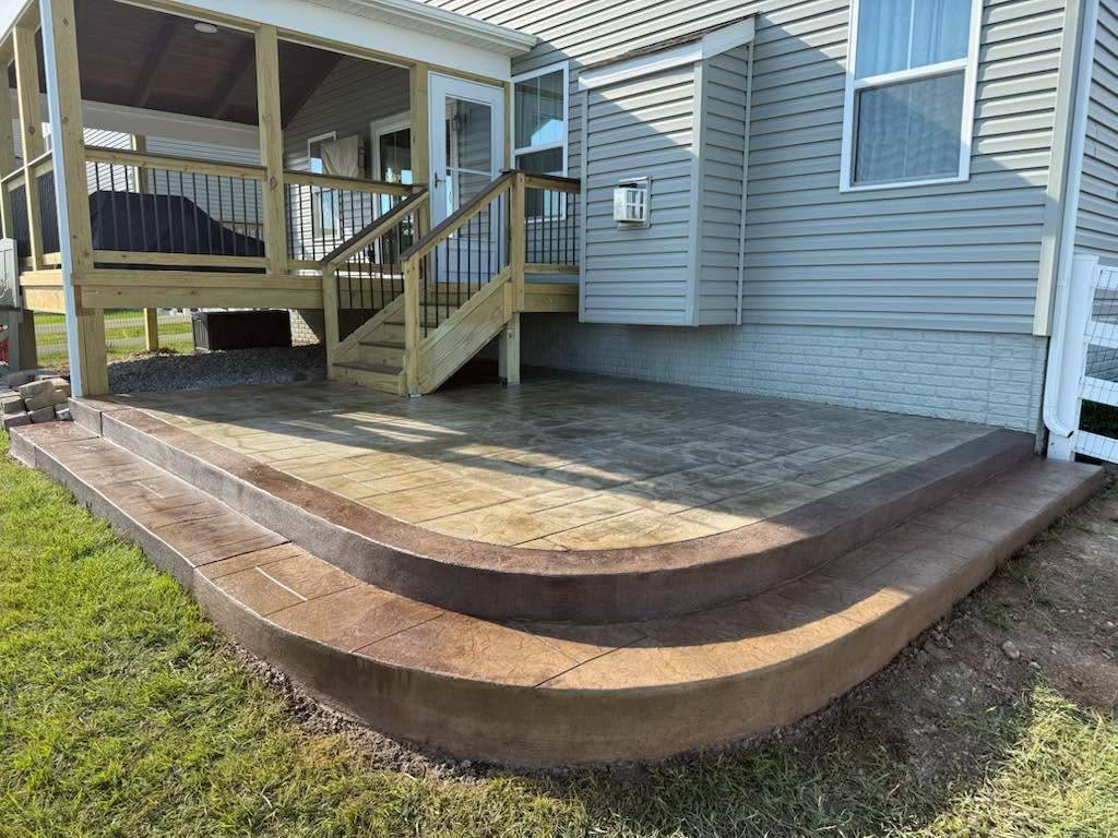 Curved stamped concrete patio with steps down to the lawn in Winchester VA