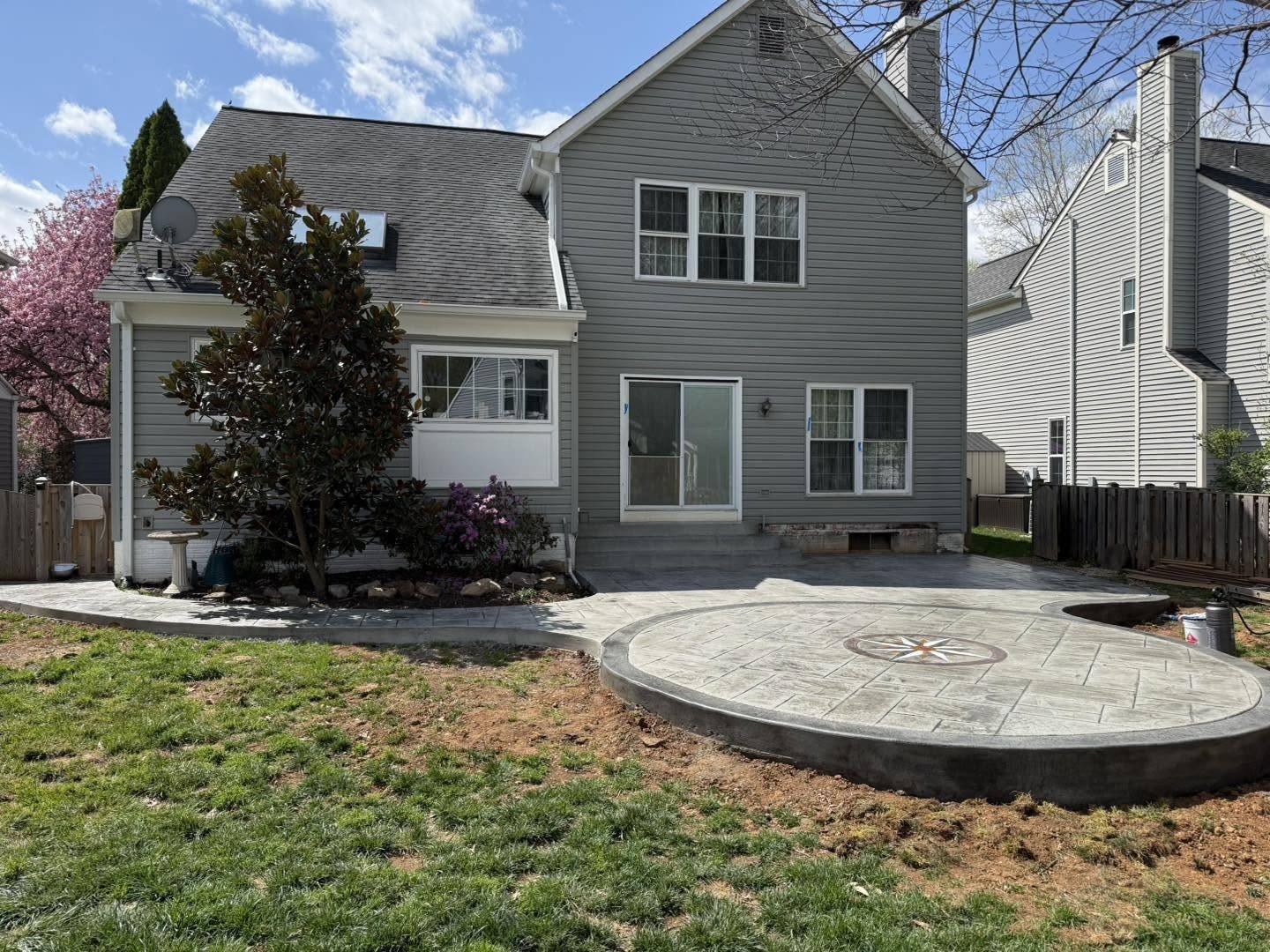 Curved stamped concrete patio beside a flowering tree in Winchester VA