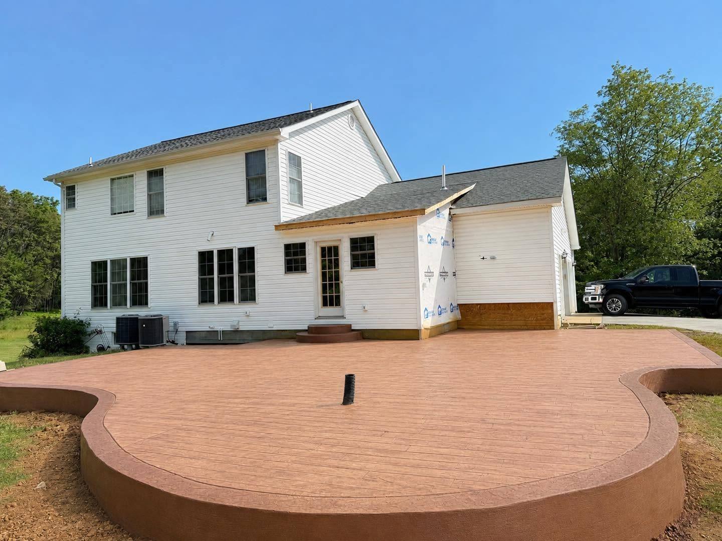 Terracotta stamped concrete patio beside a two story home in Winchester VA