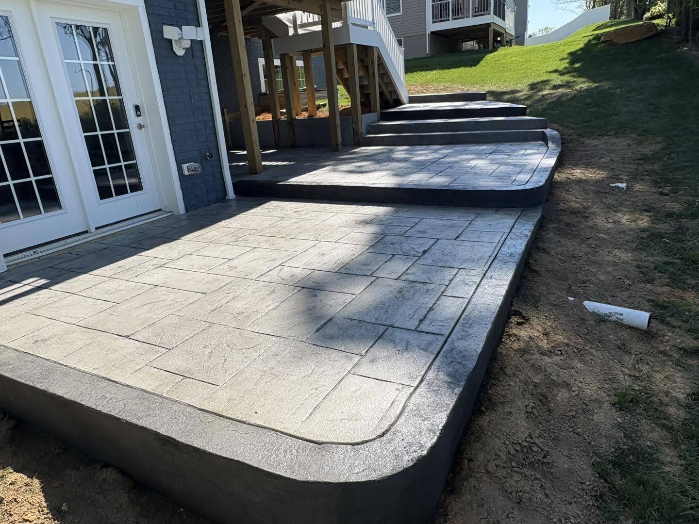 Ashlar slate stamped concrete patio outside a set of french doors in Winchester VA