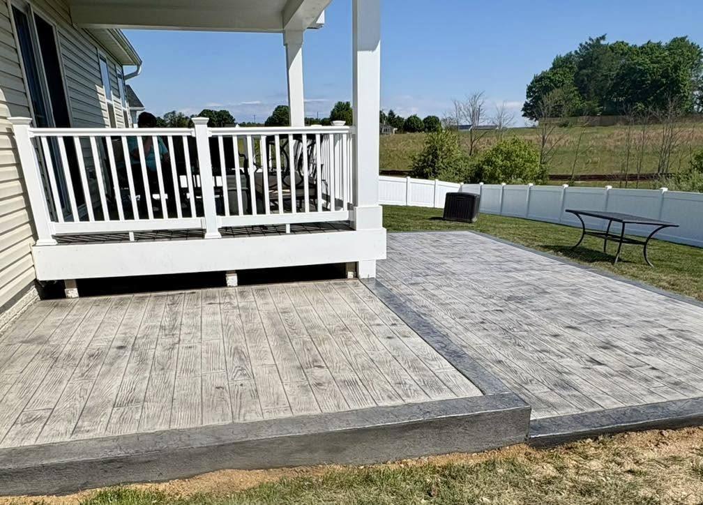 Stamped concrete patio enclosed by a white deck railing in Winchester VA